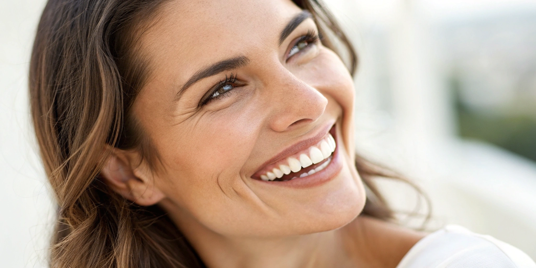 Woman with a full smile restored by different types of full arch dental implants.